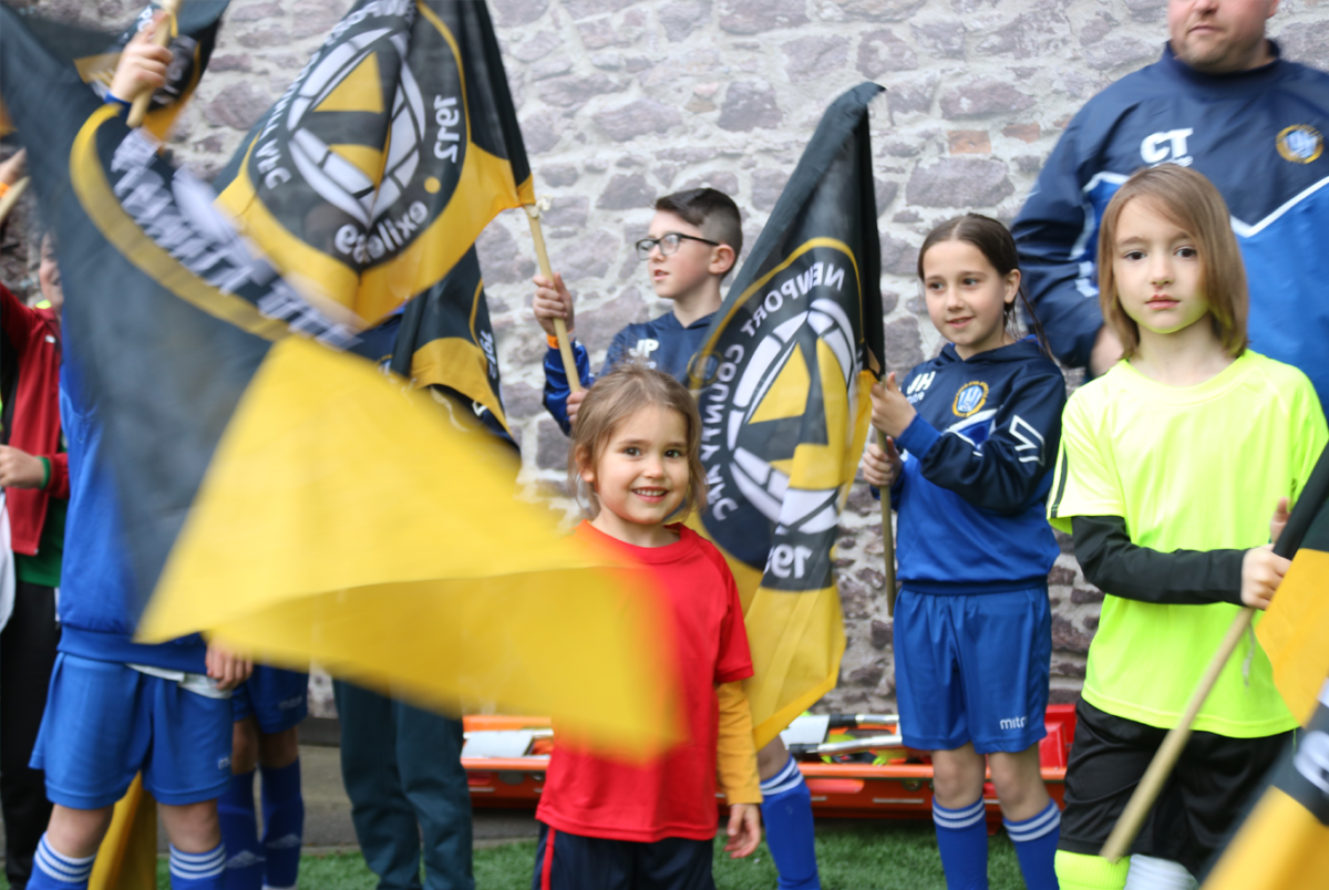 Plant ifanc yn chwifio baneri Casnewydd