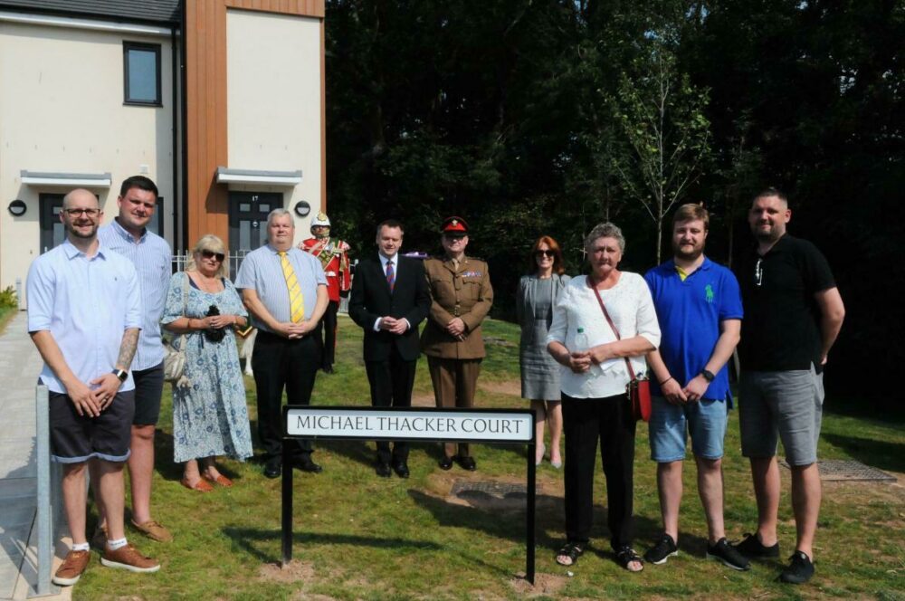A group of people stood by a street sign