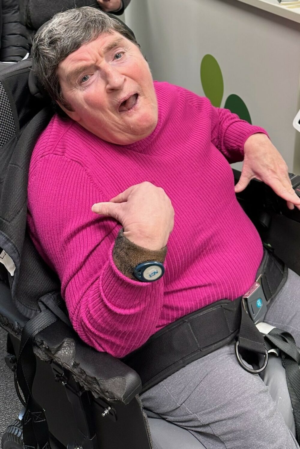 Photo of Liz smiling in her wheelchair