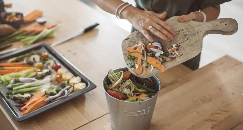 A person saving food waste to be composted