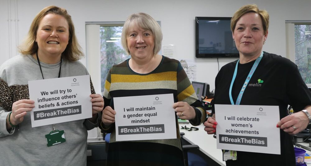 Some Melin staff members holding IWD pledge signs