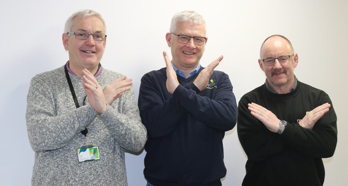 Some male Melin staff members showing the symbol for International Women's Day