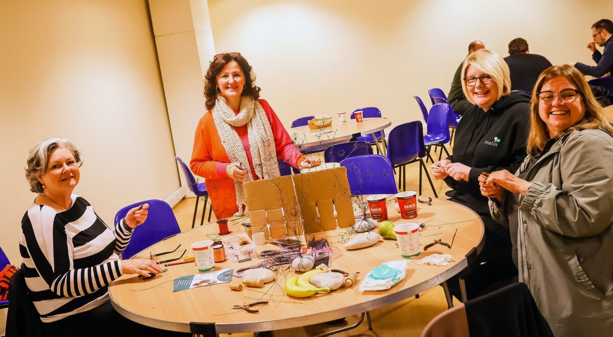 Melin staff member sat around a table, smiling